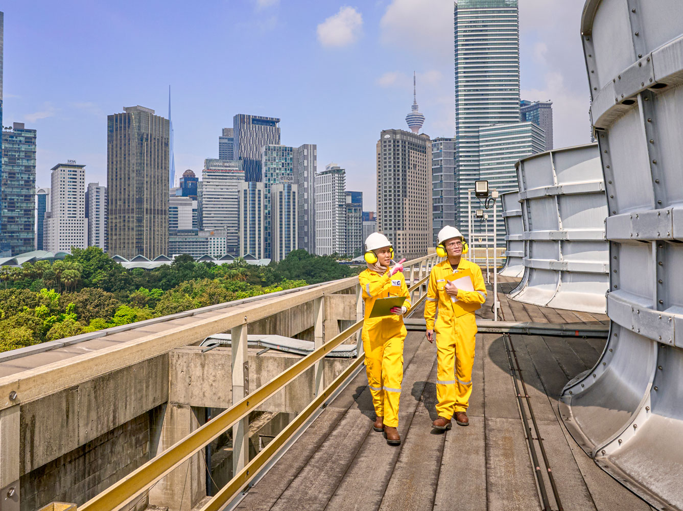 Inspecting industrial equipment, representing utilities & other businesses in a modern urban environment